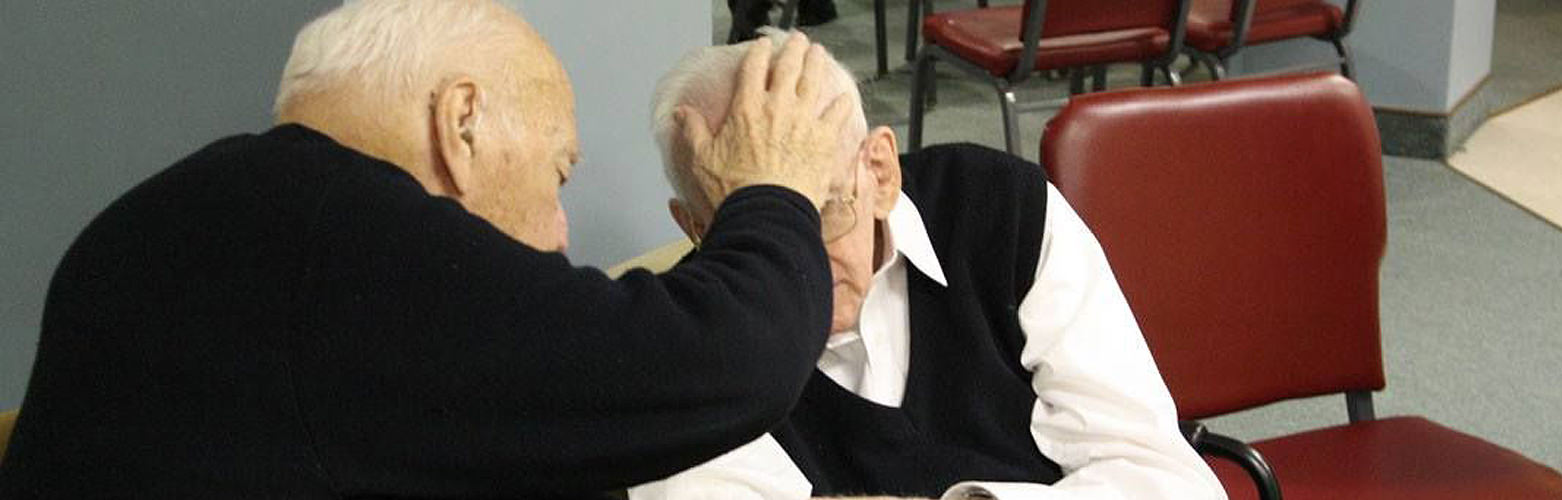 Priest anointing elderly brother