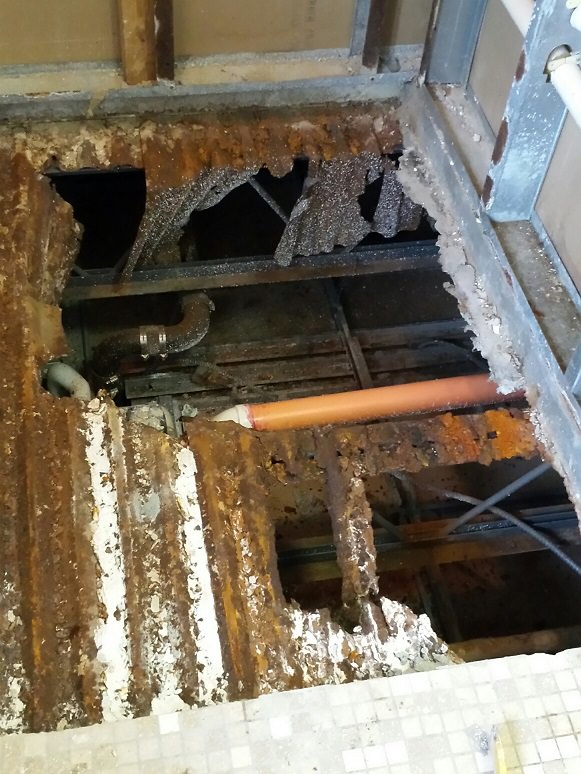 The metal plates beneath the leaking showers had rusted and collapsed. 