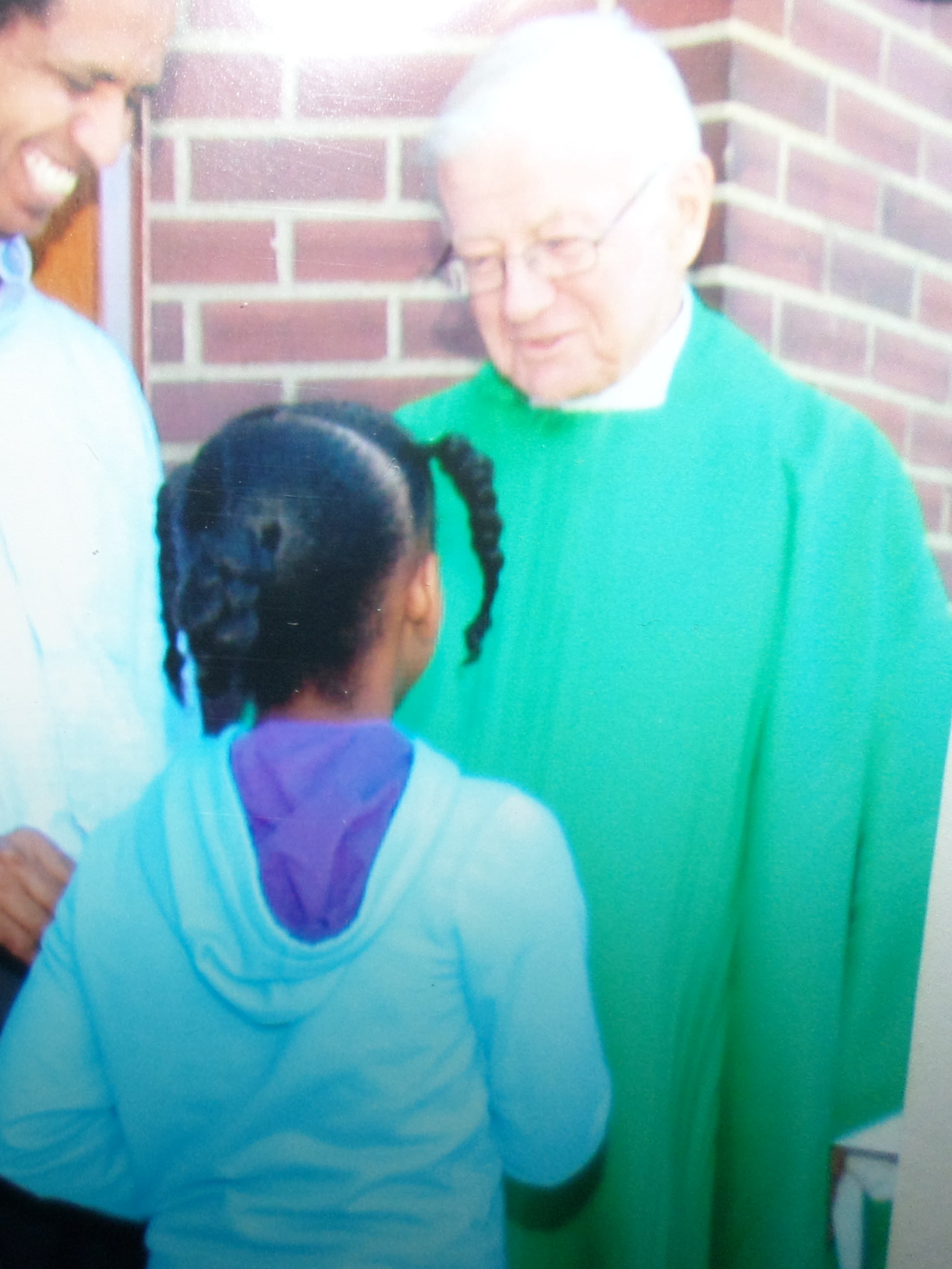 Father Frank Hall speaks with a young parishioner.