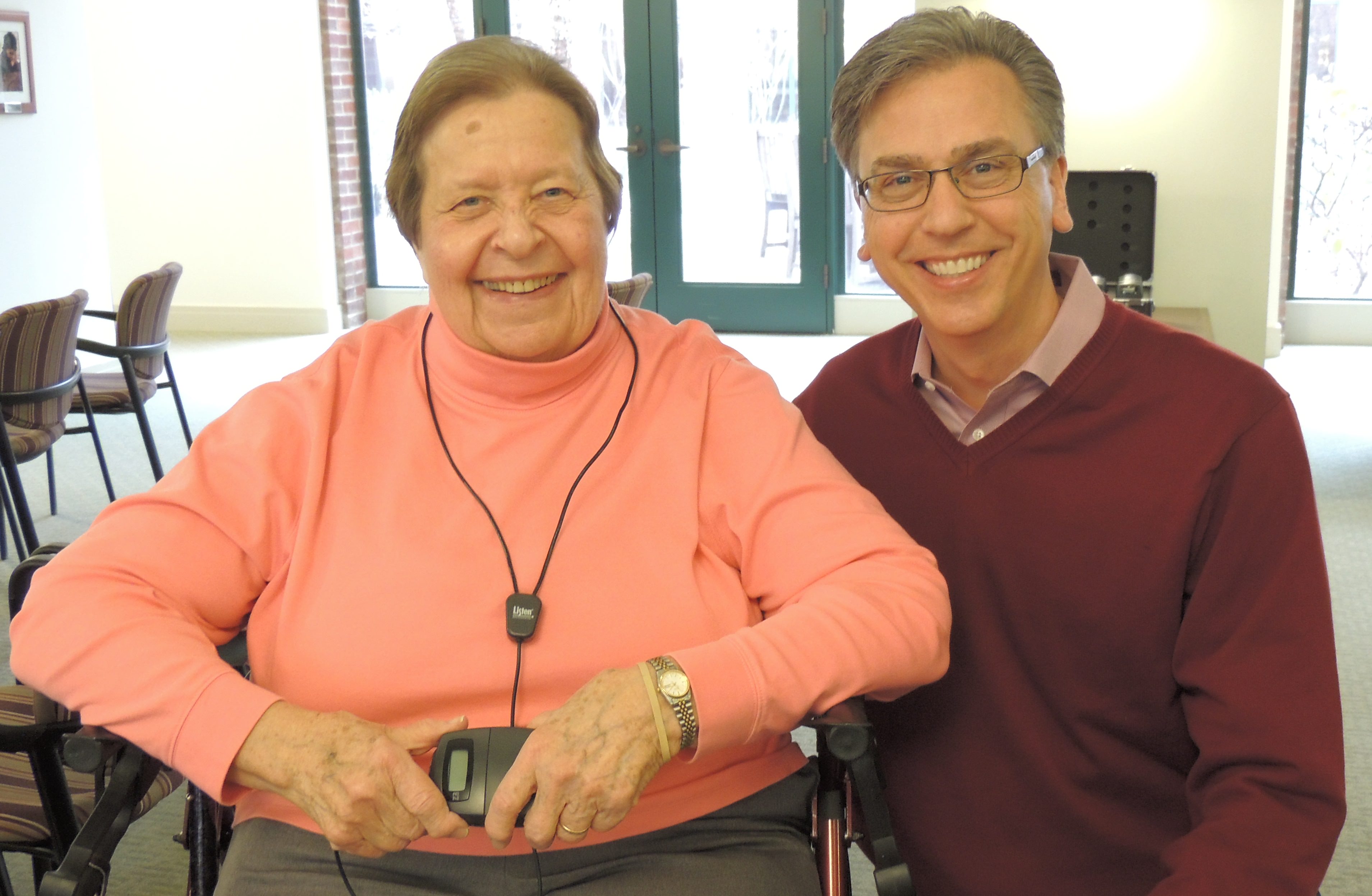 Sister Fran Mlocek poses with development director Richard DeLoof while testing the new assistive listening system. 
