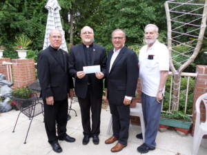 Board member John Matteo presents a check to the Missionary Servants of the Most Holy Trinity. 